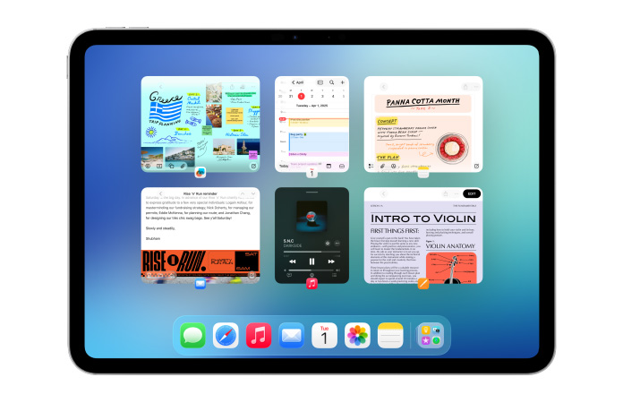 iPad, colocado na horizontal, com o ecrã a mostrar várias apps, como Calendário e Música, em seis janelas alinhadas em duas filas para mostrar a organização
