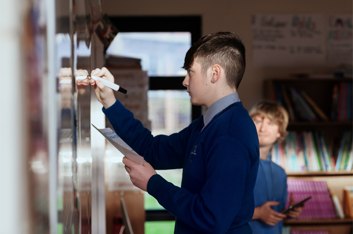 En elev som skriver på en tusjtavle ved Terence MacSwiney School.