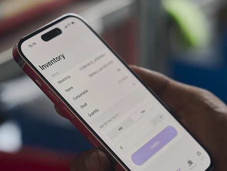 Imagem em grande plano do iPhone numa mão. O ecrã apresenta o controlo de inventário.