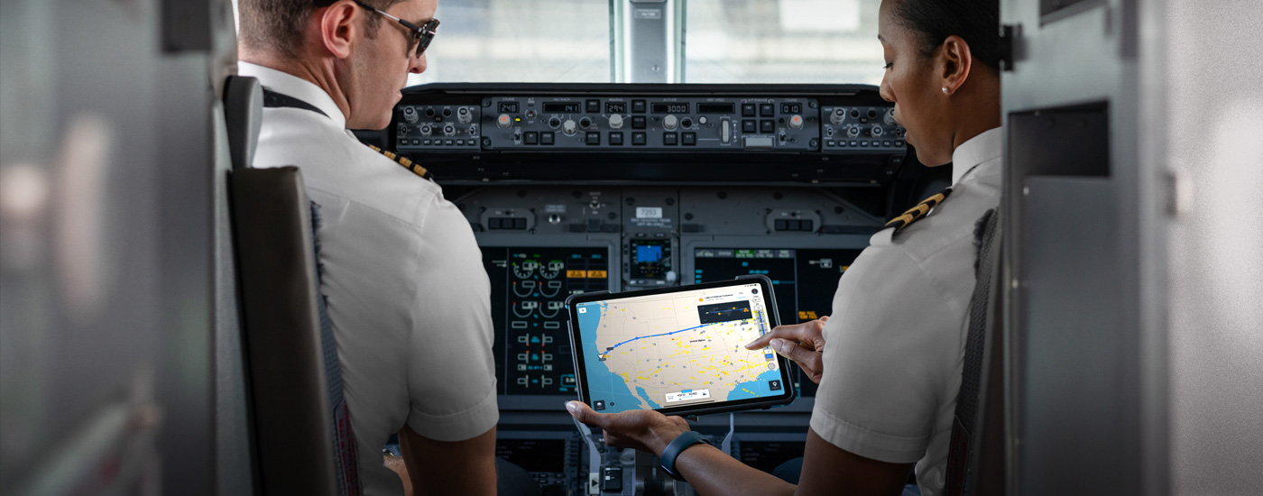 Dois pilotos no cockpit a olhar para um mapa no ecrã do iPad.