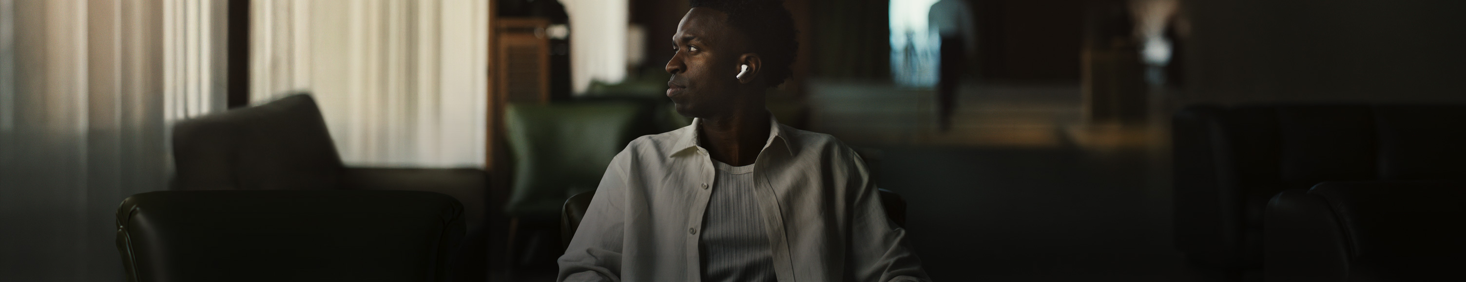 Person in weissem Hemd, den Kopf zur Seite gedreht, linker AirPods Pro 3 In-Ear Kopfhörer sichtbar