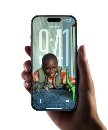 Käsi pitelee iPhone-laitetta, näkyvillä uusi Liquid Glass ‑ulkoasu, jonka avulla kellonaika muotoutuu itsestään lukitun näytön kuvan mukaan